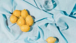 a bag of lemons and a glass of water on blue fabric that helps avoid cold and boosts immune system