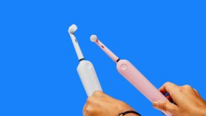 two electric toothbrushes on a blue background showing manual vs electric toothbrushes
