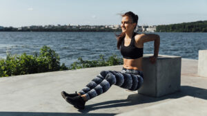 Woman doing tricep dips on a bench outside