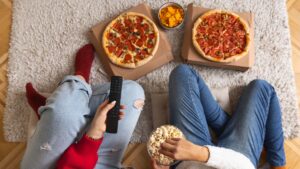 women eating carbs at night in the form of a pizza slice