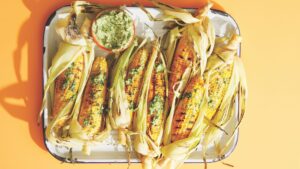 Grilled Corn in a white enamel plate on a yellow background