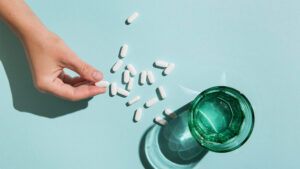 A woman taking probiotics with a glass of water
