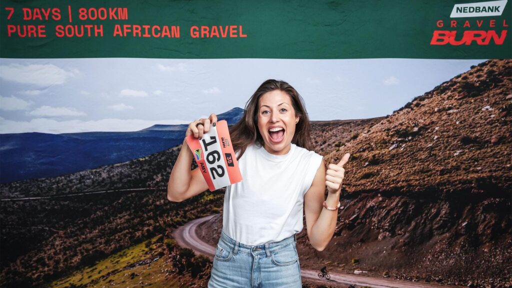 Woman holds her Nedbank Gravel Burn race number